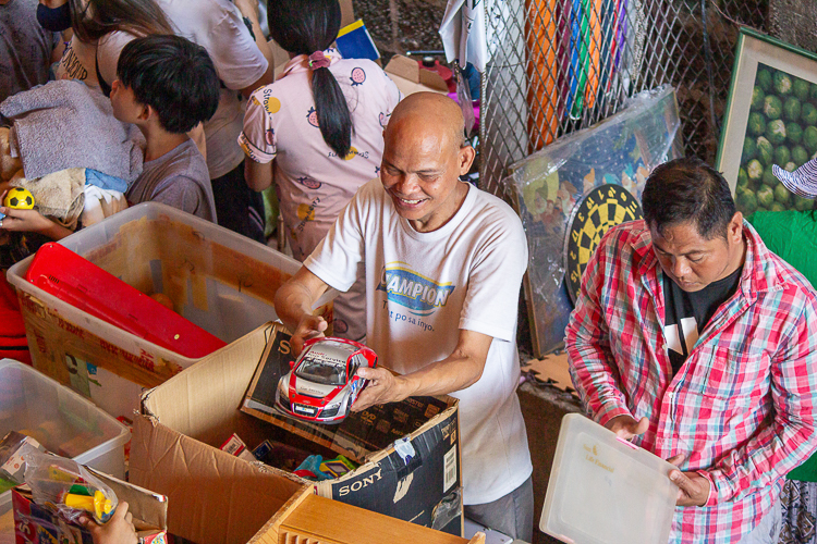 A customer happily looks at the toy car for sale at the bazaar. 【Photo by Marella Saldonido】