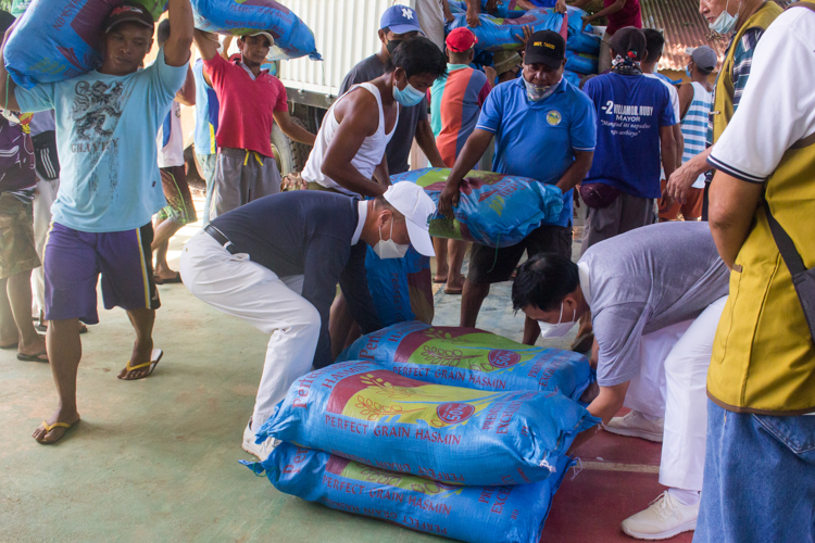 Rice being unloaded by local and Tzu Chi volunteers.【Photo by Mavi Saldonido】