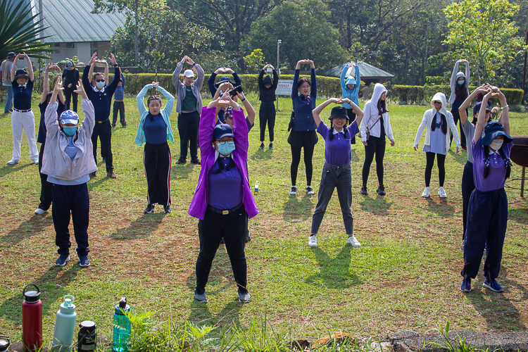 Before engaging in the physically demanding task of tree planting, stretching exercises are essential. 【Photo by Marella Saldonido】