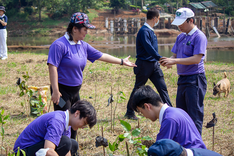 Camille Carrasco (standing left) assists her fellow Tzu Chi Youth volunteer during the tree-planting activity. 【Photo by Marella Saldonido】