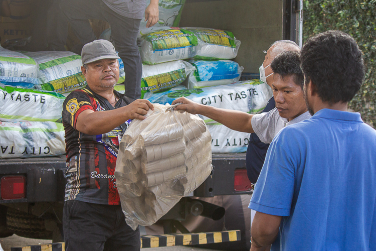 Volunteers and members of the community at Barangay Damayang Lagi unload relief goods for distribution. 【Photo by Marella Saldonido】