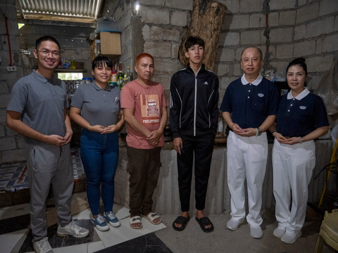 Tzu Chi volunteers pose for a photo with Jaymart Razon and his father during a home visit. 【Photo by Harold Alzaga】