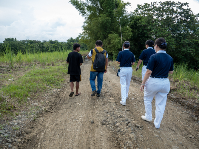 Volunteers walk to reach the residence of student applicants. 【Photo by Jeaneal Dando】