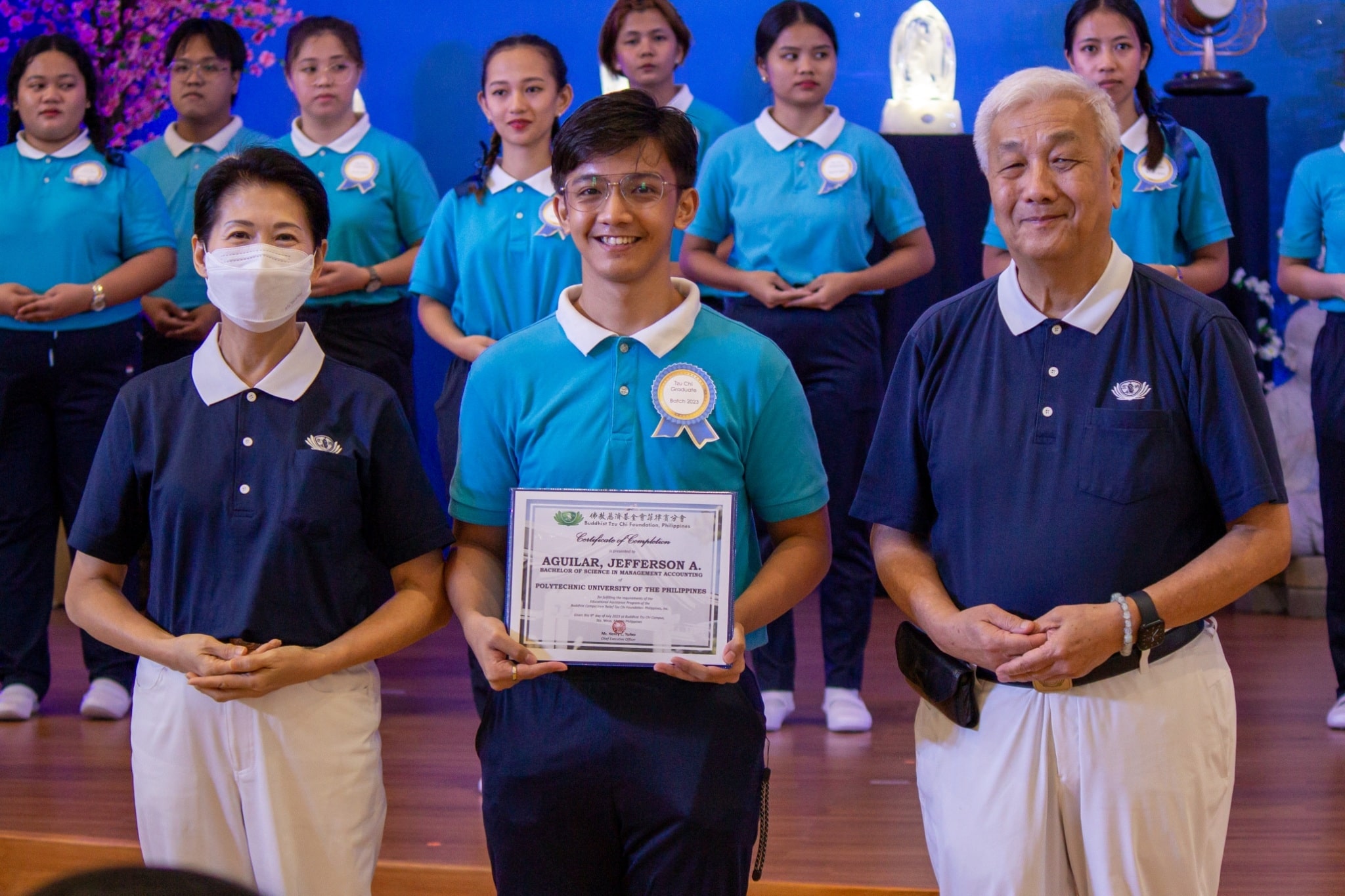 Jefferson Aguilar receives his certificate of completion from Tzu Chi Philippines CEO Henry Yuñez (right) and Deputy CEO Woon Ng (left). 【Photo by Marella Saldonido】
