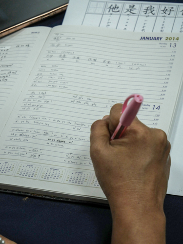 Tzu Chi staff writes Chinese characters to apply some lessons learned in their online Mandarin class. 