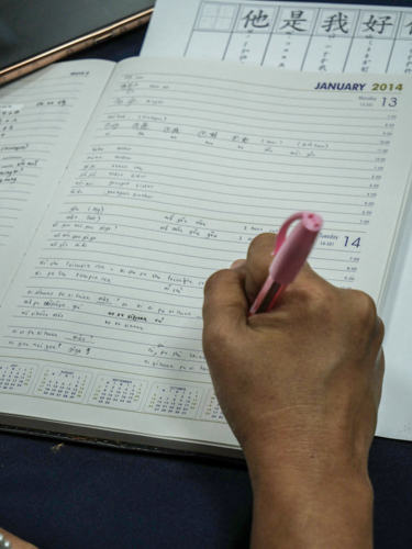 Tzu Chi staff writes Chinese characters to apply some lessons learned in their online Mandarin class.