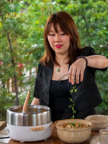 Diane tops the Kimchi-jjigae with spring onions. 【Photo by Daniel Lazar】