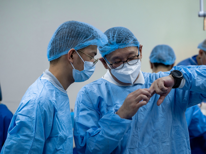 In the operating room of a medical mission in Davao, Ben Baquilod (left) listens to Tzu Chi Philippines Deputy CEO Dr. Anton Lim explain a procedure.【Photo by Daniel Lazar】