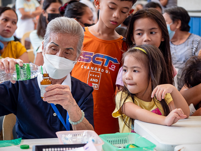 Tzu Chi volunteer Anselma Yu pours water in a medicine bottle during medical mission.【Photo by Daniel Lazar】