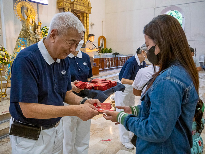 Attendees of the Typhoon Yolanda 10th Year Remembrance Mass at the Sto. Niño Church in Tacloban individually receive a red envelope (angpao) blessed by Tzu Chi founder Dharma Master Cheng Yen, just like the ones they received 10 years ago. 【Photo by Matt Serrano】