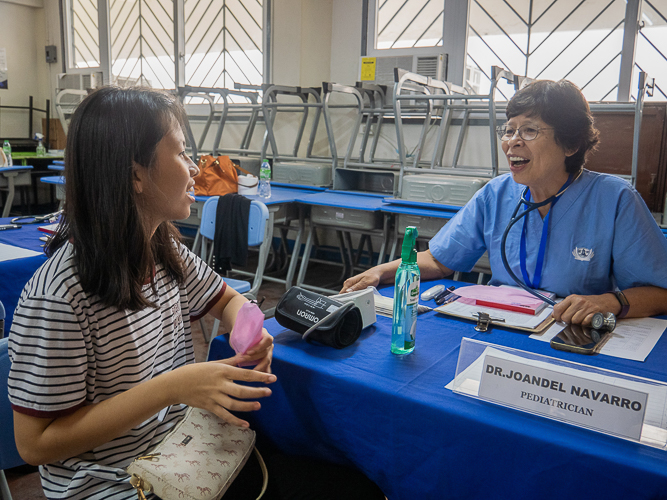 Dr. Joandel Navarro happily accommodates a patient during the medical mission.【Photo by Matt Serrano】
