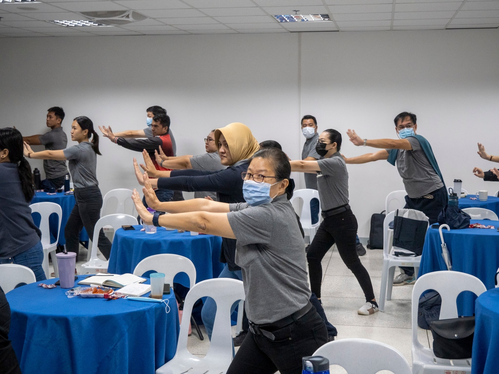 Tzu Chi Philippines employees follow the instructor livestreaming from Taiwan as he guides them in an exercise that benefits both the body and the heart. 【Photo by Matt Serrano】