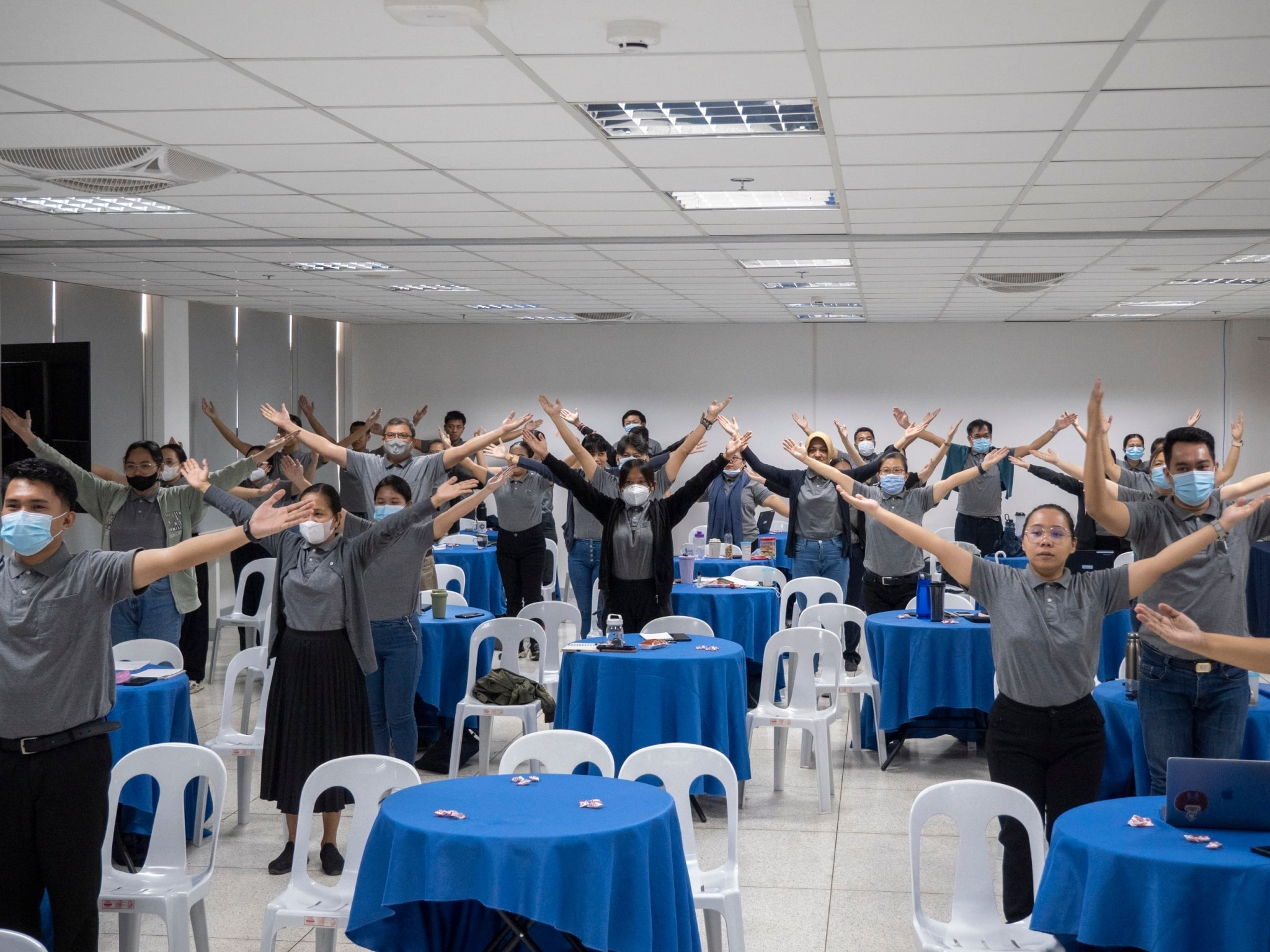 Tzu Chi Philippines employees follow the instructor livestreaming from Taiwan as he guides them in an exercise that benefits both the body and the heart. 【Photo by Matt Serrano】