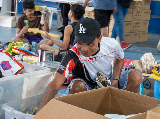 A customer enjoys rummaging through different home items sold during the bazaar. 【Photo by Matt Serrano】