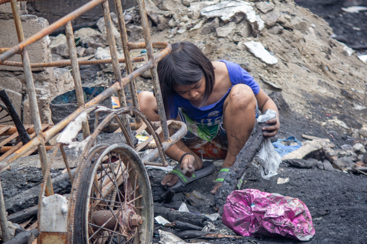 Residents survey the damages caused by a fire that razed their homes in Barangay 105, Tondo, Manila. GI sheets donated by the Tzu Chi Foundation on April 2 allowed them to begin rebuilding their homes. 【Photo by Marella Saldonido】