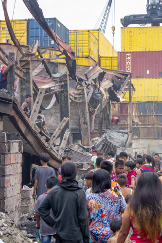 Residents survey the damages caused by a fire that razed their homes in Barangay 105, Tondo, Manila. GI sheets donated by the Tzu Chi Foundation on April 2 allowed them to begin rebuilding their homes. 【Photo by Marella Saldonido】