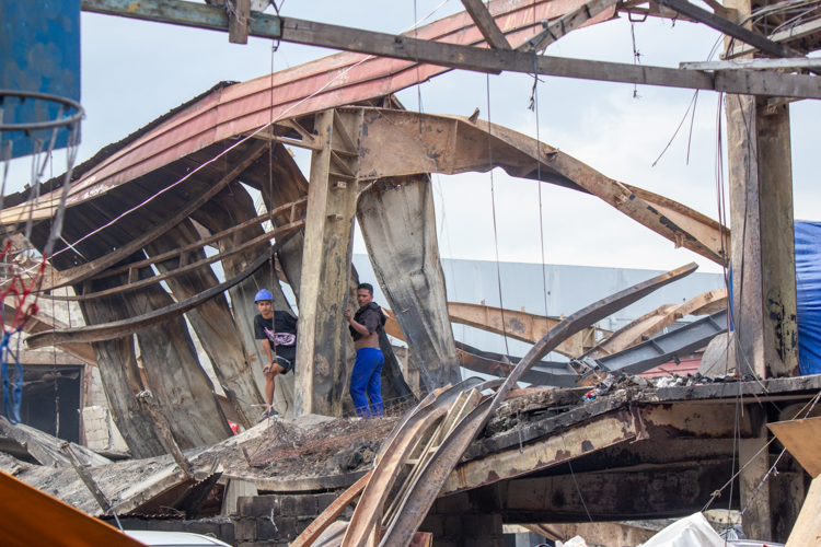 Residents survey the damages caused by a fire that razed their homes in Barangay 105, Tondo, Manila. GI sheets donated by the Tzu Chi Foundation on April 2 allowed them to begin rebuilding their homes. 【Photo by Marella Saldonido】