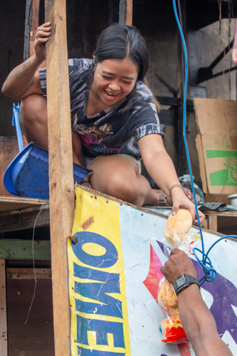 After providing Tondo fire victims with packed vegetarian meals the night before, Tzu Chi volunteers returned the following morning to offer bread to the community. 【Photo by Marella Saldonido】