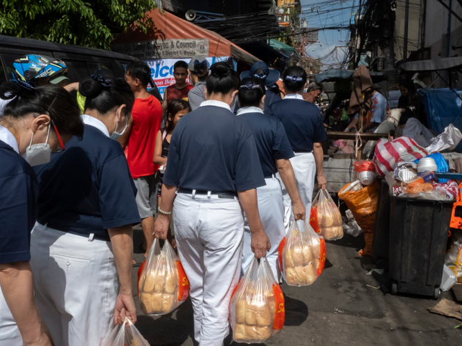 After providing Tondo fire victims with packed vegetarian meals the night before, Tzu Chi volunteers returned the following morning to offer bread to the community. 【Photo by Dorothy Castro】