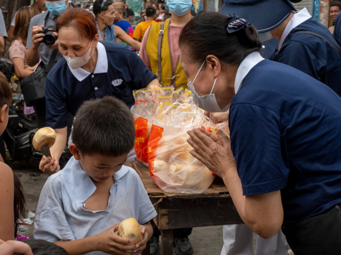 After providing Tondo fire victims with packed vegetarian meals the night before, Tzu Chi volunteers returned the following morning to offer bread to the community. 【Photo by Dorothy Castro】