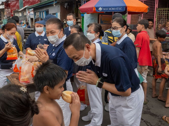 After providing Tondo fire victims with packed vegetarian meals the night before, Tzu Chi volunteers returned the following morning to offer bread to the community. 【Photo by Dorothy Castro】