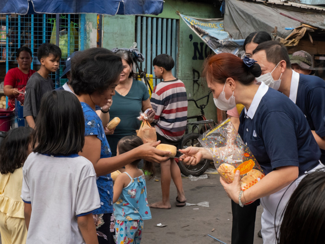 After providing Tondo fire victims with packed vegetarian meals the night before, Tzu Chi volunteers returned the following morning to offer bread to the community. 【Photo by Dorothy Castro】