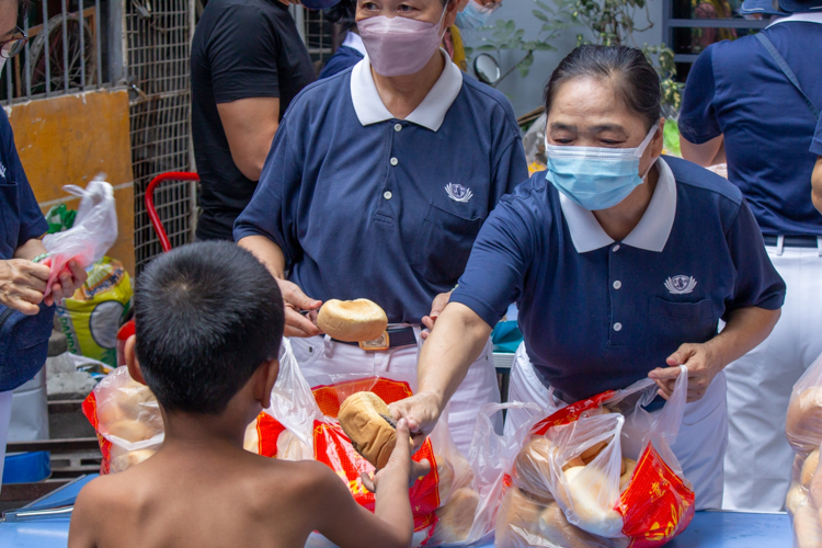 After providing Tondo fire victims with packed vegetarian meals the night before, Tzu Chi volunteers returned the following morning to offer bread to the community. 【Photo by Marella Saldonido】