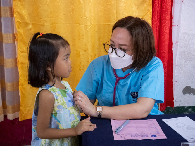 A volunteer pediatrician as she performs an initial examination to a patient.