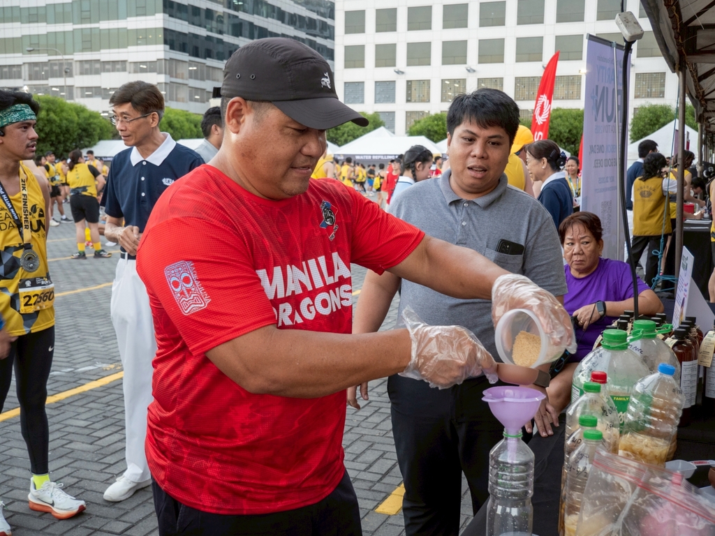 A runner tries his hand at mixing bio-enzyme, a chemical-free cleanser and fertilizer.