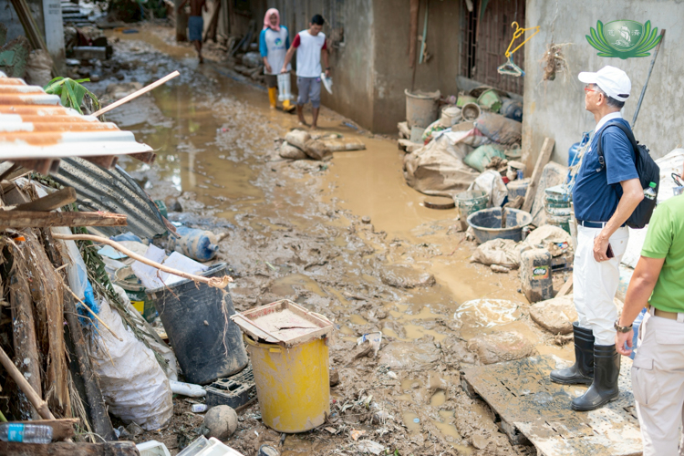 Tzu Chi Cebu volunteer Jack Gaisano looks on as fellow volunteers survey a typhoon-hit area.