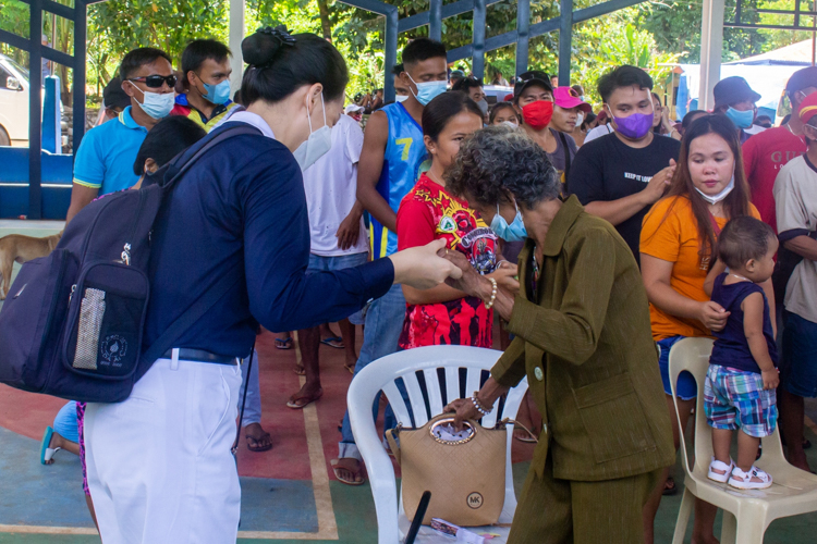 Tzu volunteer helping elderly recipient get up from her chair.【Photo by Mavi Saldonido】