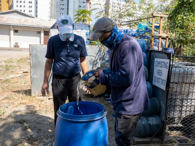 A generous amount of water is poured onto newly prepared compost drums to help prevent crumbling compost. 【Photo by Matt Serrano】