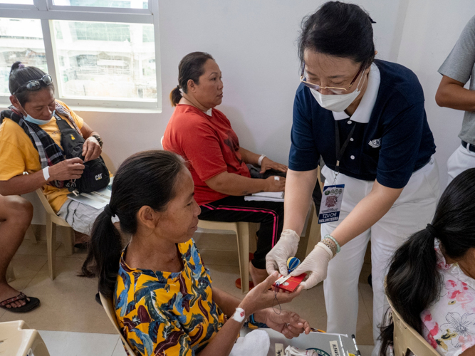 A patient receives a red envelope (angpao), a commemorative token from the Tzu Chi founder Dharma Master Cheng Yen. 【Photo by Ben Baquilod】