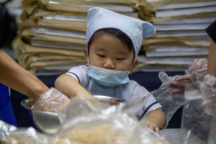 Lance Ong is eagerly engaged in mixing ingredients for the pistachio cranberry chocolate bark.【Photo by Matt Serrano】