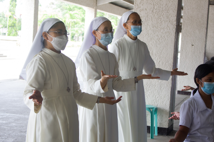 Sisters of Mary nuns join in performing the One Family sign language. 【Photo by Matt Serrano】