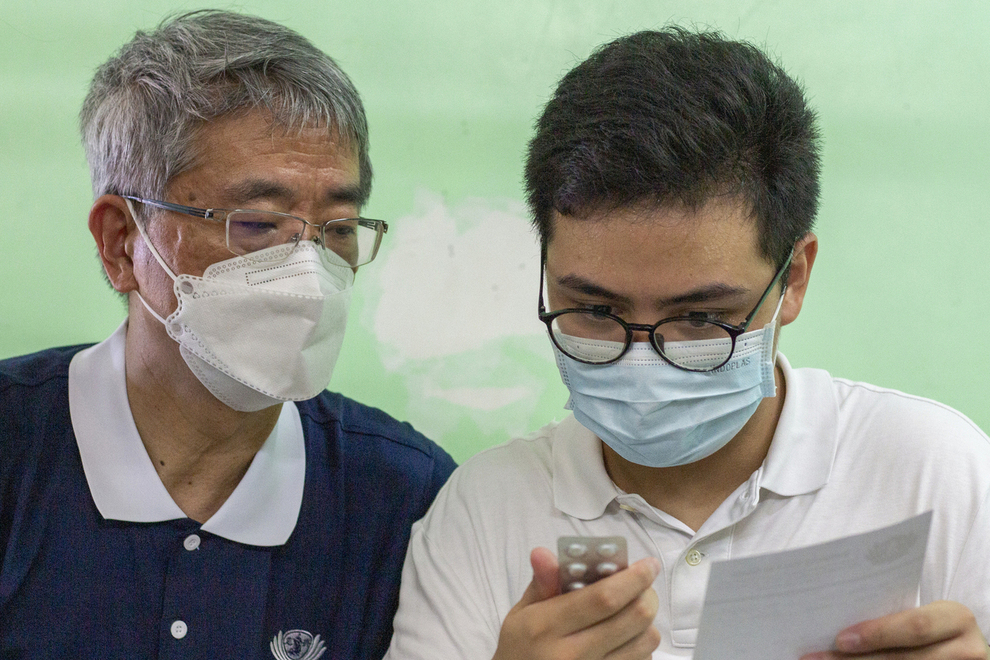 Taiwan Tzu Chi University Medical School professor (left) and volunteer Vince Vitug (right) check the medications to ensure that they are the correct kind and dosage at the pharmacy.