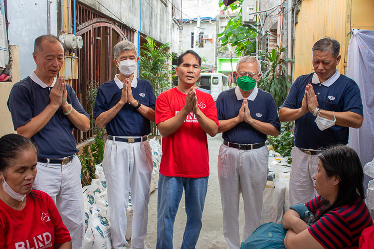 Blind Republic Philippines president Ramir Sayson (center) stands with palms together with Tzu Chi volunteers as they sing Tzu Chi’s “Love and Care for All.”  【Photo by Marella Saldonido】