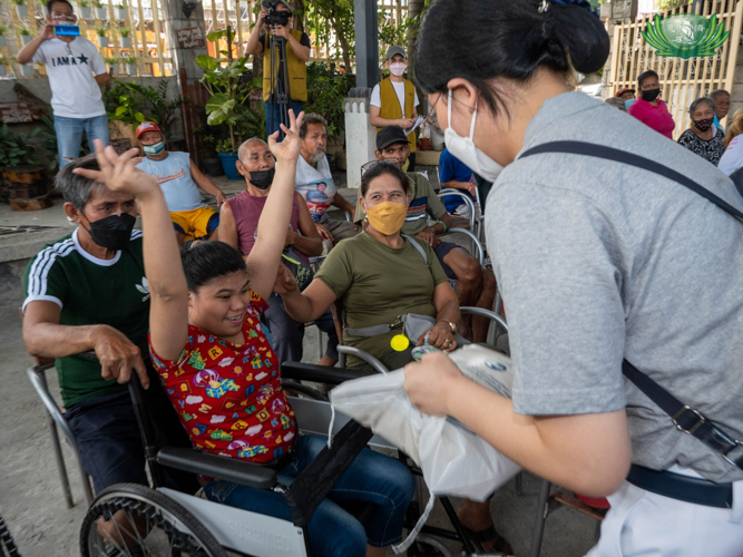 Marissa Corpuz and her family happily receives 10 kilos of rice from Tzu Chi. 【Photo by Kendrick Yacuan】