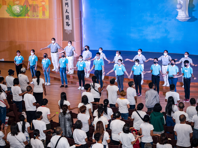 Tzu Chi volunteers and scholars lead the performance of ‘One Family’ sign language.【Photo by Daniel Lazar】