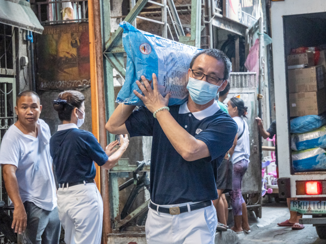 A Tzu Chi volunteer unloads relief goods for the beneficiaries. 【Photo by Matt Serrano】