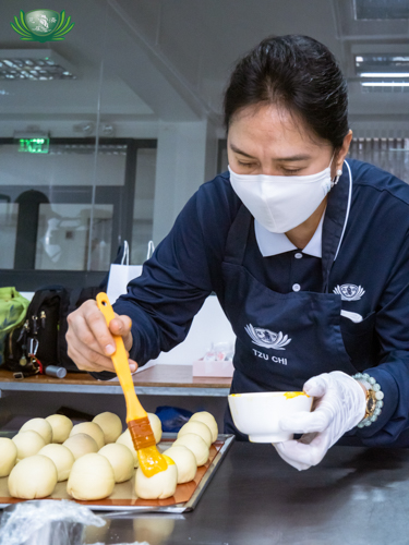 Olga Vendivel brushes egg yolk on a mooncake. Mooncakes were sold during the Mooncake Festival last September to raise funds for high flow nasal cannula oxygen machines. The machines went to hospitals with COVID-19 patients.