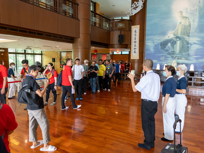 Tzu Chi volunteers explain the history and significance of Tzu Chi’s coin banks, which guests received as souvenirs. 【Photo by Marella Saldonido】