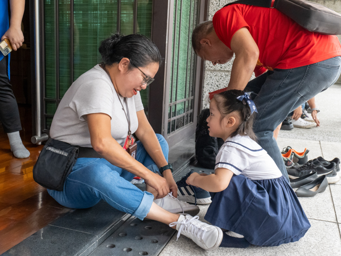 A guest needed assistance tying her shoelaces, and a Tzu Chi Great Love Preschool student was happy to assist. 【Photo by Marella Saldonido】