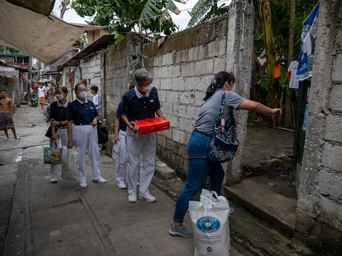 Tzu Chi volunteers visited long-time beneficiary Socorro Bello to celebrate her 100th birthday. They surprised the centenarian with a bag of groceries, rice, cash allowance, and birthday cake.【Photo by Jeaneal Dando】