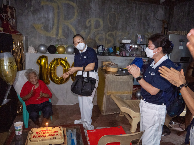 Tzu Chi volunteers visited long-time beneficiary Socorro Bello to celebrate her 100th birthday. They surprised the centenarian with a bag of groceries, rice, cash allowance, and birthday cake. 【Photo by Jeaneal Dando】