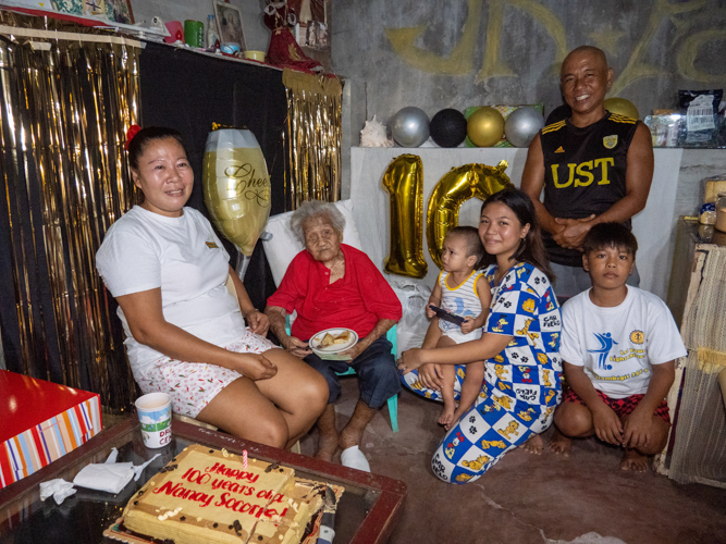 “Tzu Chi is such a big help to her,” says Jean Domingo (leftmost), Socorro’s distant relative who takes care of the centenarian.  “She’s very happy because she didn’t expect that you will come. You are the only ones who gave her a birthday cake.” 【Photo by Jeaneal Dando】