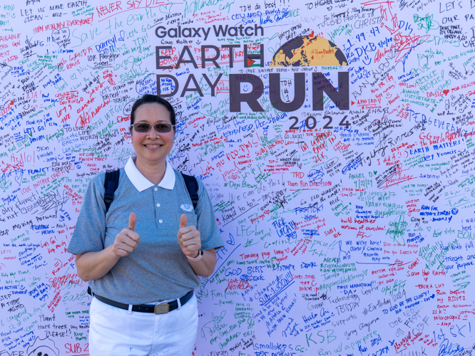 Mission accomplished: Posing before the runners’ dedication wall at the Runrio Galaxy Watch Earth Day Run. 【Photo by Matt Serrano】