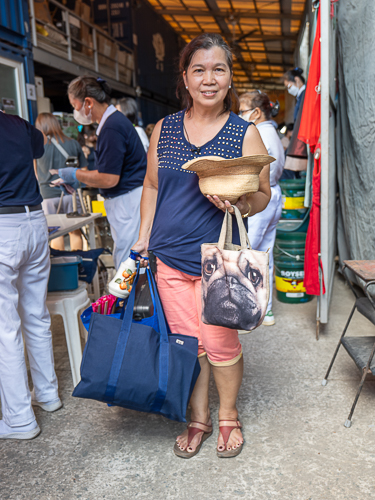 Bacood Elementary School teacher Carol Billones poses with the items she bought at the bazaar. 【Photo by Marella Saldonido】