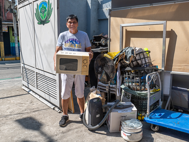 Barangay 621 Chairman Juan Philip Manabat poses with the items he purchased at the bazaar. 【Photo by Marella Saldonido】