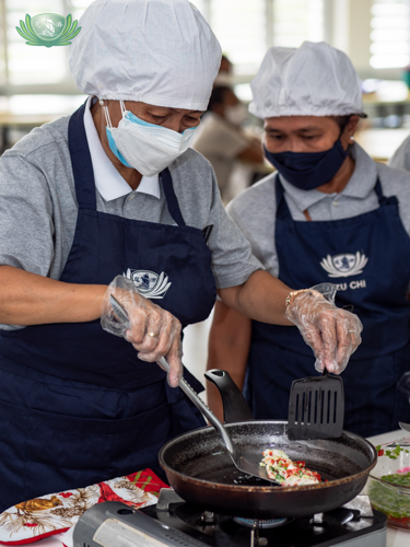 Volunteers cooking a healthy veggie omelette【Photo by Daniel Lazar】